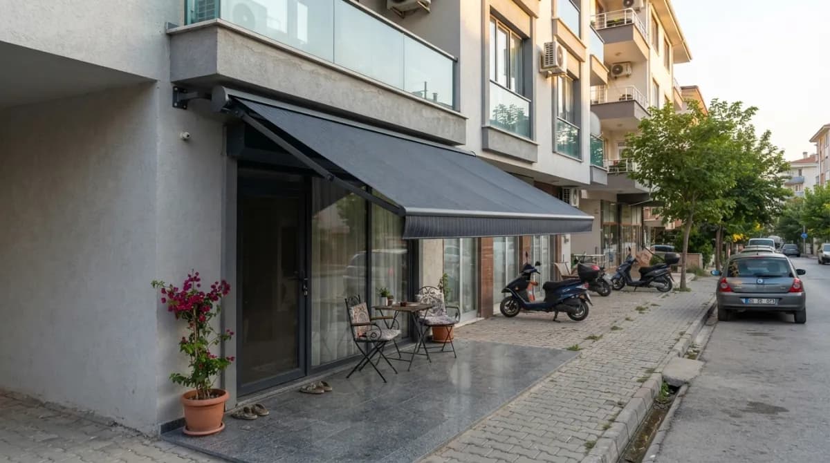 İzmir'de bir balkona uygulanmış dikmesiz mafsallı tente
